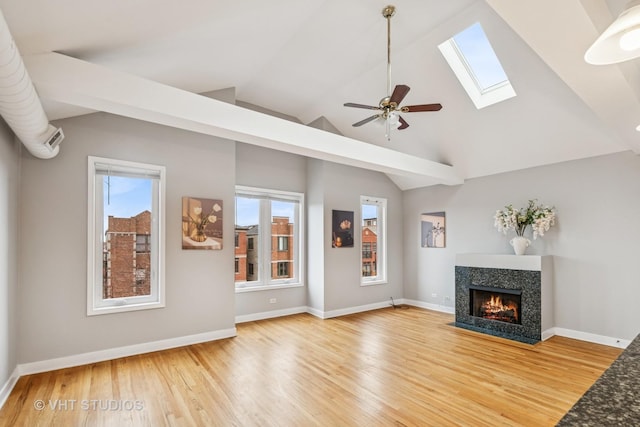 2336 W Harrison St Unit 4, Chicago, IL 60612 - unfurnished living room featuring light wood-type flooring, a fireplace with flush hearth, a skylight, lofted ceiling, and ceiling fan
