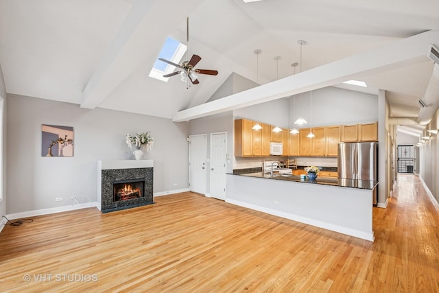 2336 W Harrison St Unit 4, Chicago, IL 60612 - unfurnished living room featuring a skylight, high vaulted ceiling, light wood-type flooring, a tile fireplace, and ceiling fan
