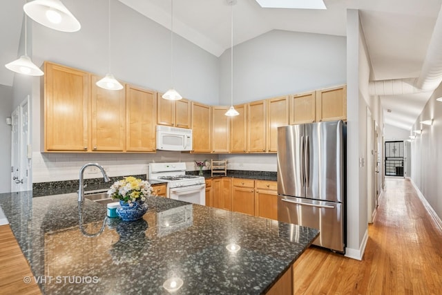 2336 W Harrison St Unit 4, Chicago, IL 60612 - kitchen featuring white appliances, a peninsula, light wood finished floors, light brown cabinets, and a skylight