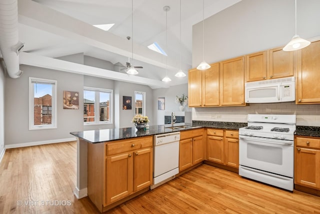 2336 W Harrison St Unit 4, Chicago, IL 60612 - kitchen featuring white appliances, a sink, a peninsula, a skylight, and light wood-style flooring
