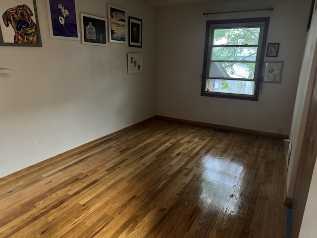 empty room featuring wood finished floors and baseboards