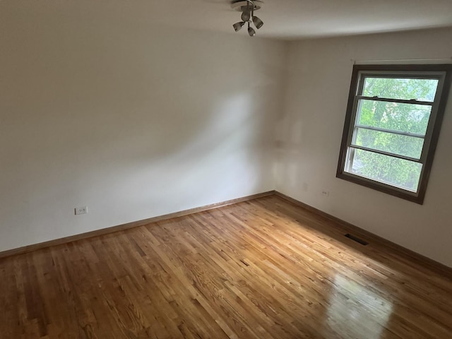 empty room featuring wood finished floors and baseboards