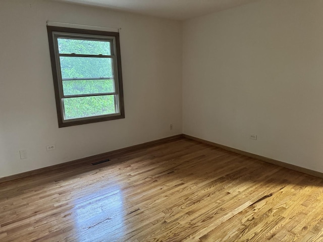 spare room with wood finished floors and baseboards