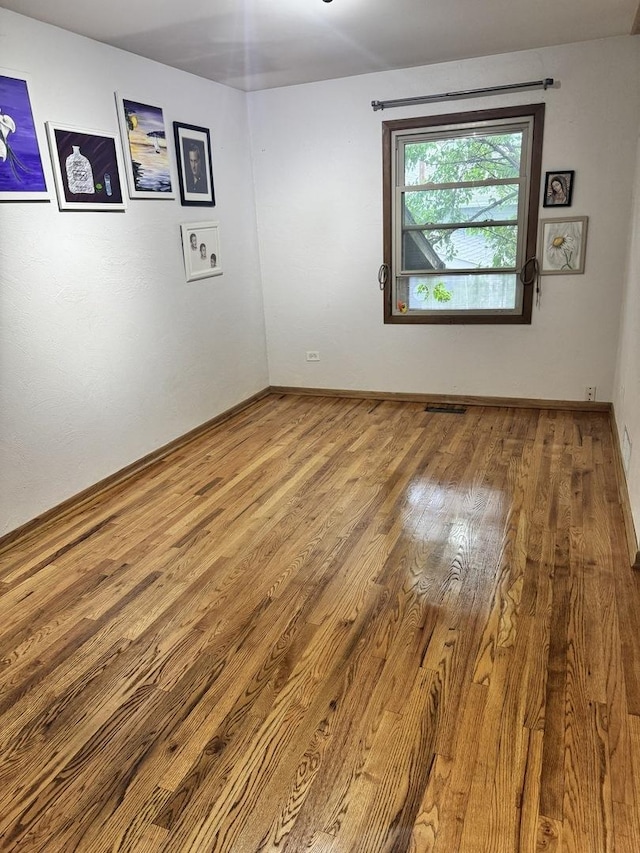 unfurnished room featuring wood finished floors and baseboards