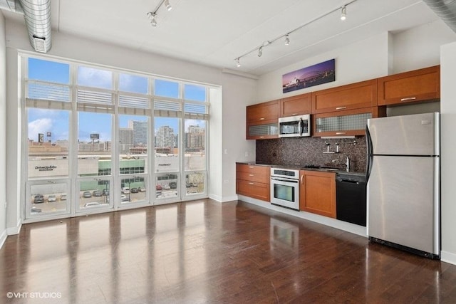 kitchen featuring brown cabinetry, appliances with stainless steel finishes, and track lighting