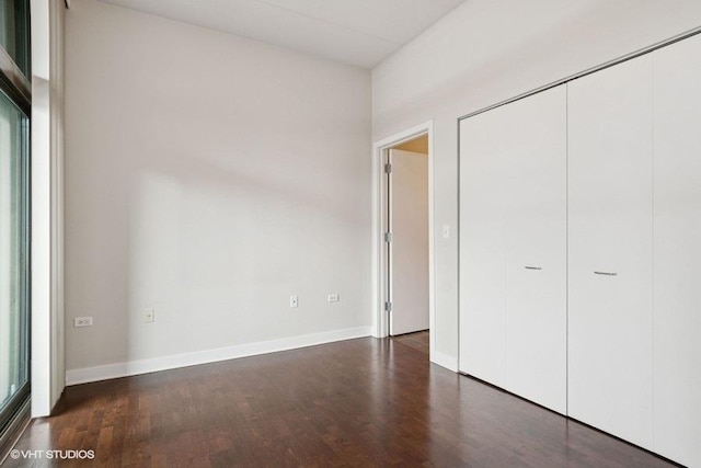 unfurnished bedroom with baseboards, a closet, and wood finished floors