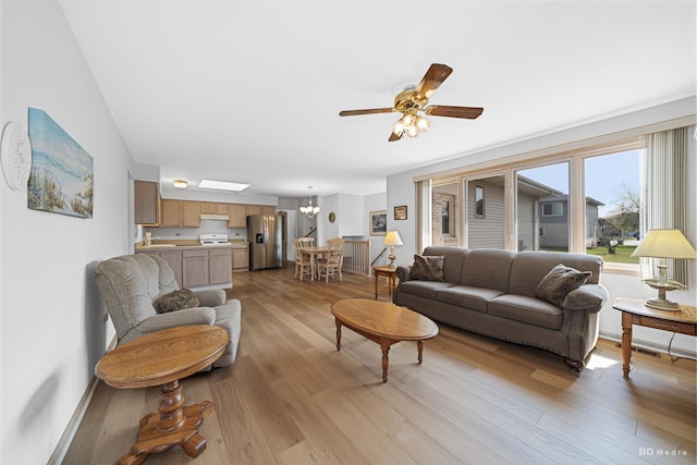 9147 Boardwalk Ter, Orland Hills, IL 60487 - living area with light wood-style flooring, a skylight, and ceiling fan with notable chandelier