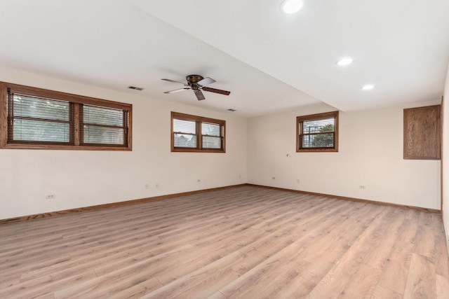 empty room with light wood-style flooring, ceiling fan, baseboards, and visible vents