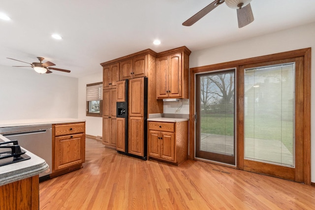 kitchen with light wood-style flooring, paneled refrigerator, and a ceiling fan