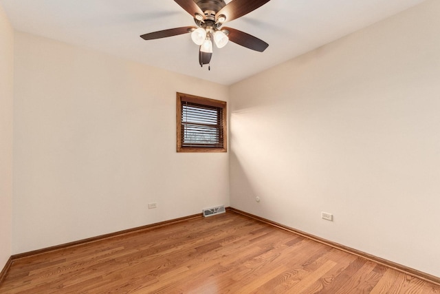 spare room with visible vents, light wood-style flooring, ceiling fan, and baseboards