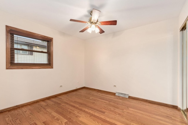 empty room featuring visible vents, baseboards, a ceiling fan, and light wood-style floors