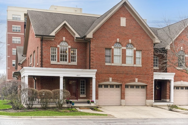 view of front of property with a porch, driveway, a garage, and brick siding