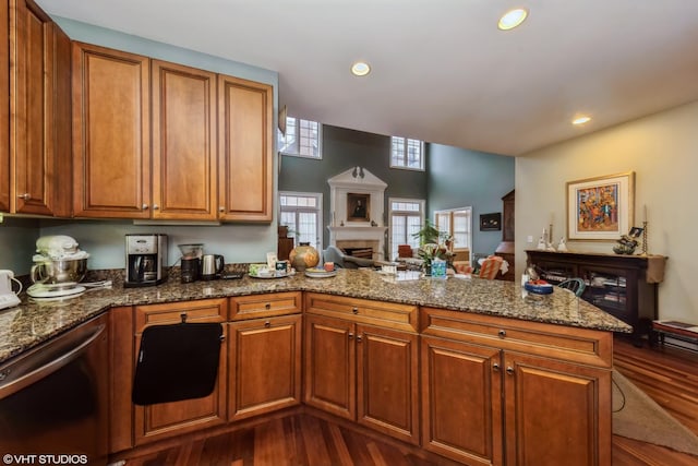 kitchen featuring brown cabinets, a peninsula, dishwasher, and dark wood finished floors
