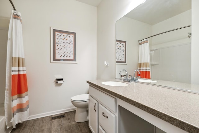 full bath with wood finished floors, visible vents, toilet, vanity, and baseboards