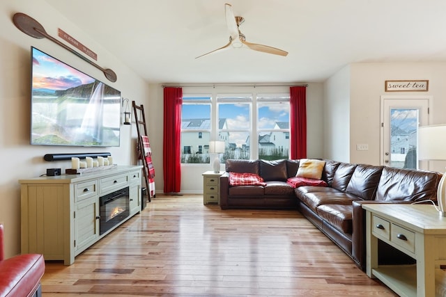 living area with light wood-style floors and ceiling fan