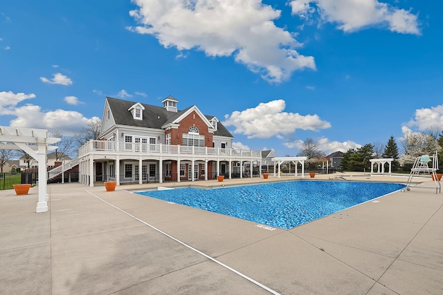 pool featuring stairs, fence, a pergola, a wooden deck, and a patio area