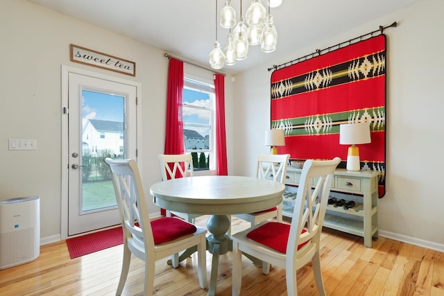 dining space featuring baseboards, a chandelier, and wood-type flooring