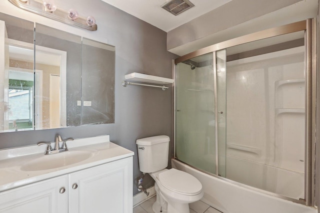 full bath featuring combined bath / shower with glass door, vanity, tile patterned floors, toilet, and visible vents