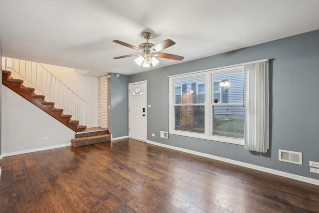 unfurnished living room featuring stairs, visible vents, baseboards, and ceiling fan