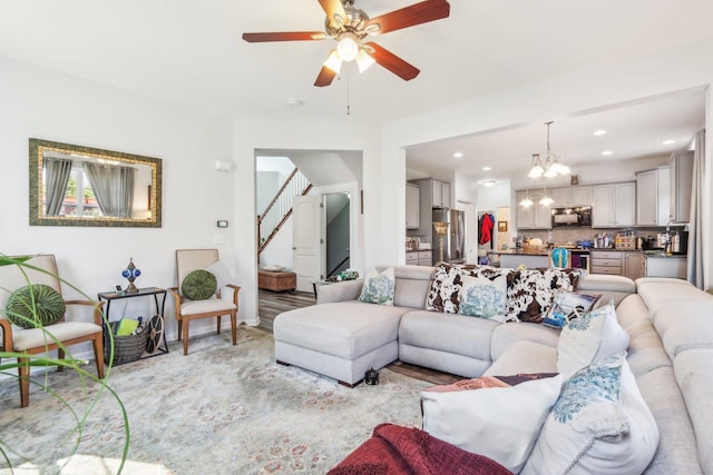 living room featuring recessed lighting, stairway, and ceiling fan with notable chandelier