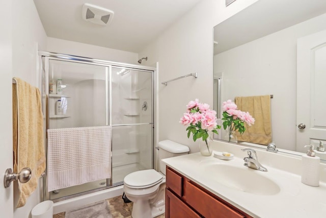 bathroom featuring visible vents, vanity, a shower stall, and toilet