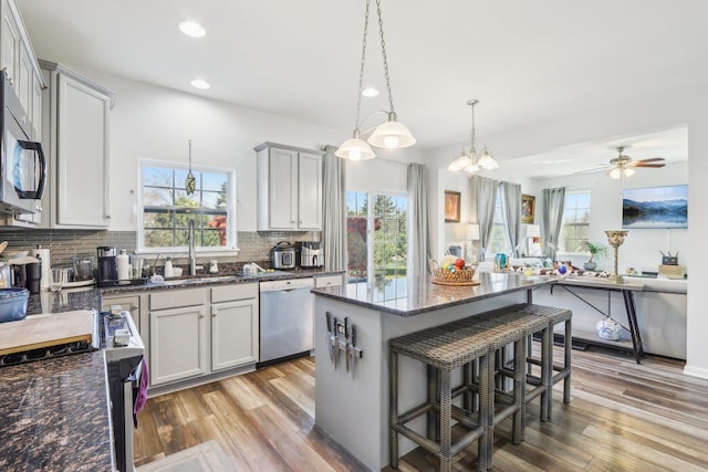kitchen featuring a wealth of natural light, dishwasher, recessed lighting, and a kitchen breakfast bar