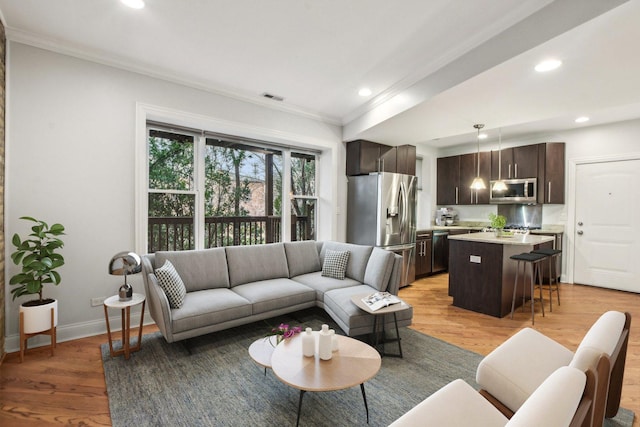 living room featuring crown molding, visible vents, recessed lighting, and light wood-style floors