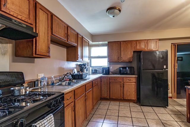 kitchen with brown cabinets, black appliances, and under cabinet range hood