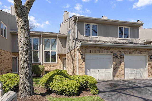 22W128 Butterfield Rd, Glen Ellyn, IL 60137 - tri-level home featuring a chimney, brick siding, an attached garage, and asphalt driveway