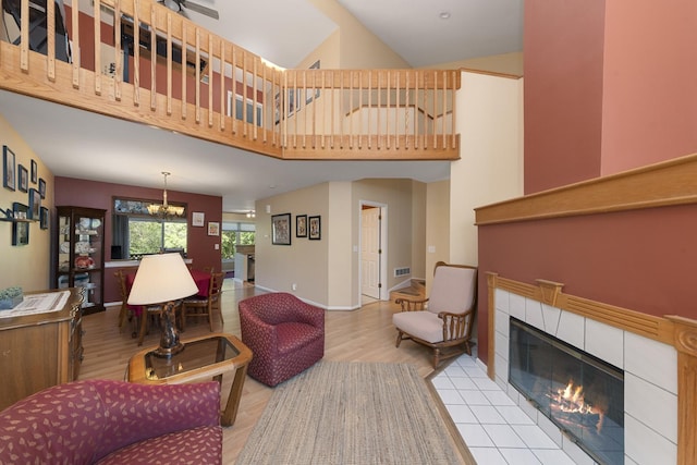 22W128 Butterfield Rd, Glen Ellyn, IL 60137 - living area with a tiled fireplace, wood finished floors, a chandelier, a high ceiling, and baseboards