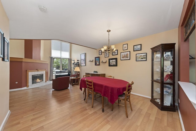 22W128 Butterfield Rd, Glen Ellyn, IL 60137 - dining room with a chandelier, light wood-style flooring, a fireplace, and baseboards