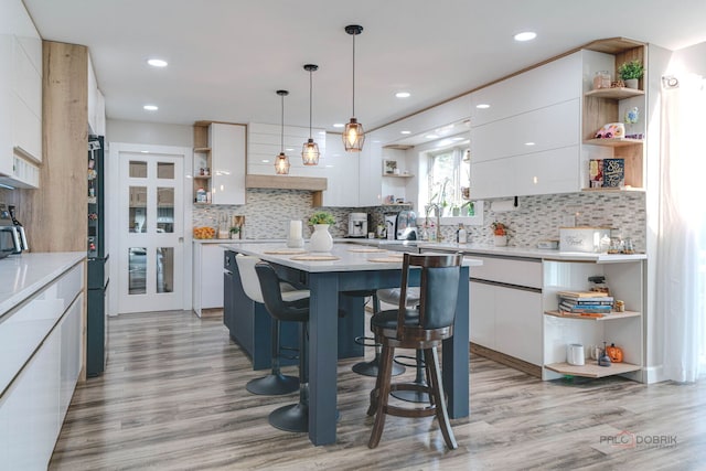 kitchen featuring modern cabinets, a kitchen island, open shelves, and white cabinetry