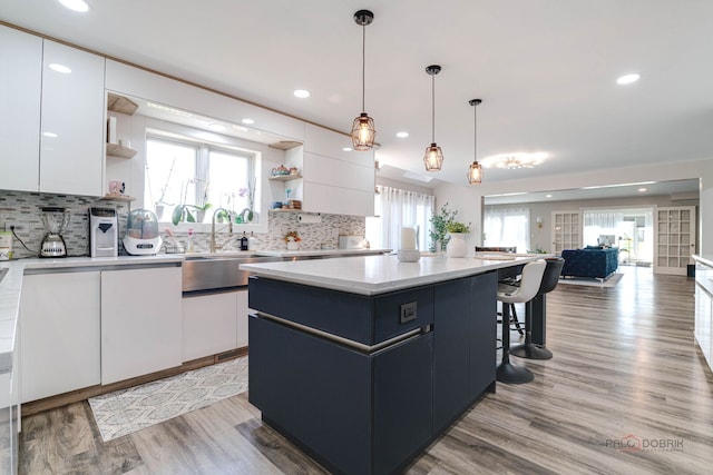 kitchen featuring a center island, recessed lighting, open shelves, and white cabinetry