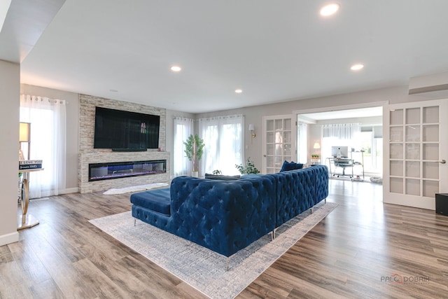 living room featuring recessed lighting, baseboards, wood finished floors, and a fireplace