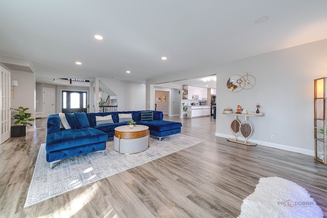 living room featuring baseboards, recessed lighting, and wood finished floors