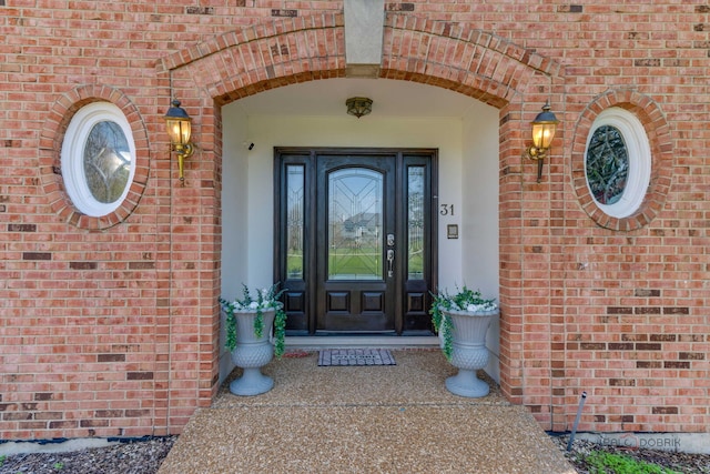 entrance to property featuring brick siding