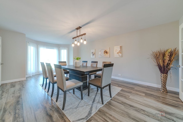 dining room with an inviting chandelier, wood finished floors, and baseboards