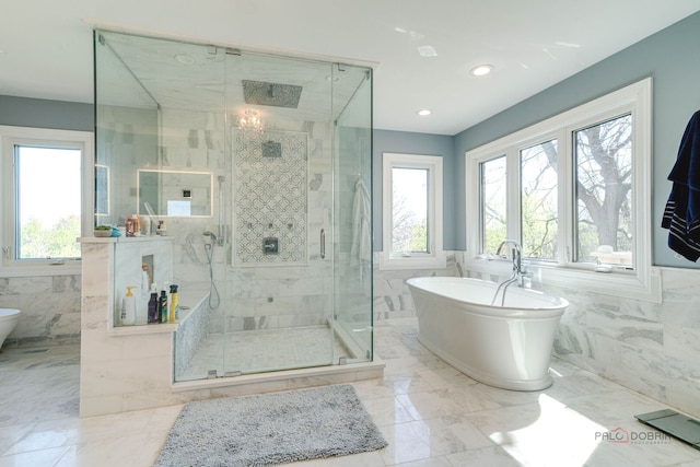 bathroom with a healthy amount of sunlight, a soaking tub, a stall shower, and tile walls