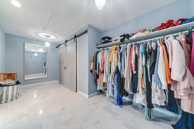 spacious closet with a barn door and attic access
