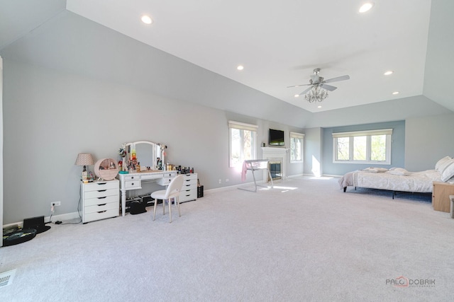 carpeted bedroom featuring a glass covered fireplace, recessed lighting, baseboards, and multiple windows
