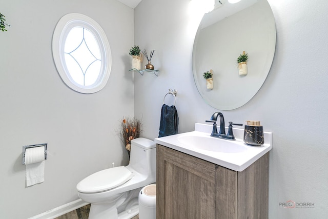 bathroom with wood finished floors, vanity, and toilet