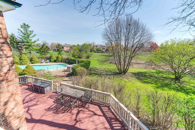 deck with outdoor dining space and an outdoor pool