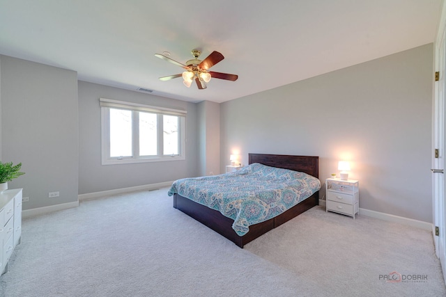 bedroom with baseboards, visible vents, and light colored carpet