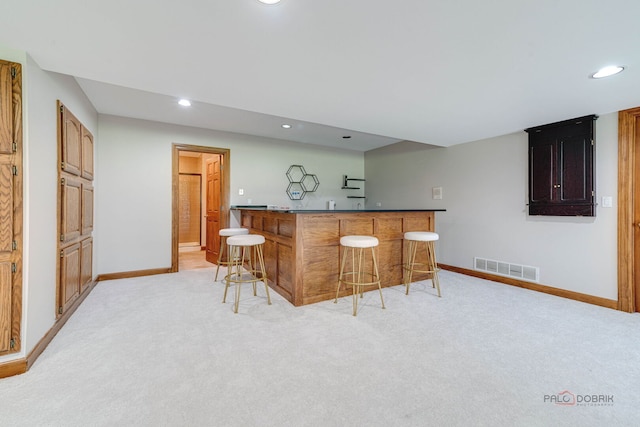kitchen with a kitchen bar, recessed lighting, and baseboards