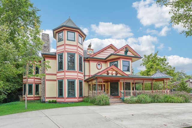 view of front facade featuring covered porch and a chimney