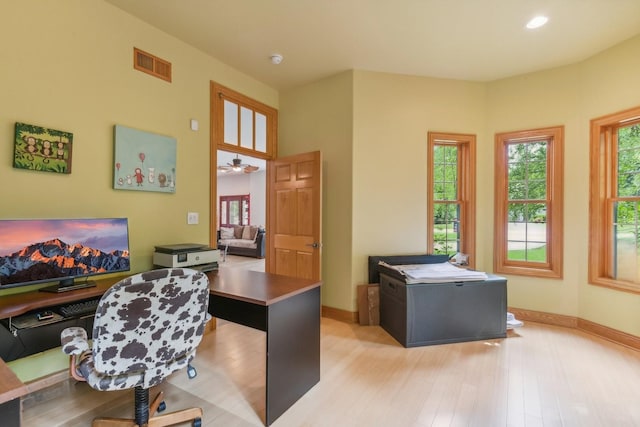 office with light wood-style floors, visible vents, and baseboards