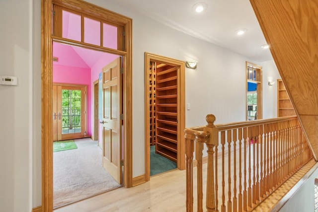 hallway with recessed lighting, an upstairs landing, and wood finished floors