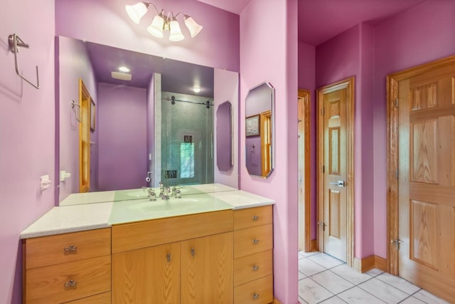 full bath with a stall shower, vanity, and tile patterned flooring