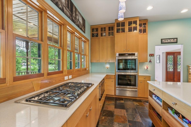 kitchen featuring stone finish flooring, recessed lighting, a warming drawer, appliances with stainless steel finishes, and light countertops