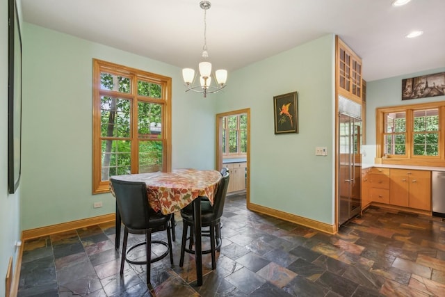 dining area with recessed lighting, baseboards, an inviting chandelier, and stone tile flooring